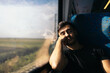 © Pedro Merino/Stocksy - Asleep young man traveling by train