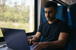 © Pedro Merino/Stocksy - Freelance man working with laptop on the train