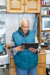 © Moy Ortega/Stocksy - Smiling senior on video call at house with a digital tablet