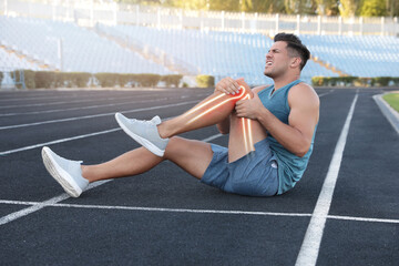 Sticker - Digital composite of highlighted bones and man suffering from leg pain at stadium