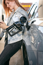 Woman Waits While Filling Gas Tank