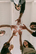 © VISUALSPECTRUM/Stocksy - Five People Holding Hands Together at End of Counseling Session