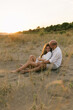 © STUDIO TAURUS/Stocksy - Careless young couple sitting at the beach and hugging