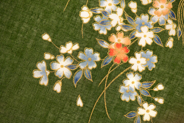 White flowers part of the old japanese fabric pattern on green background.