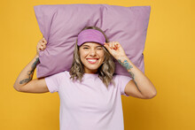 Calm Young Woman She Wears Purple Pyjamas Jam Hold Sleep Eye Mask Pillow Behind Head Look Aside Wink Rest Relax At Home Isolated On Plain Yellow Background Studio Portrait Good Mood Night Nap Concept