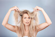 Hair, portrait and woman in studio for hair care, problem and fail or hair loss against grey background. Confused, girl and model with split ends, dry and tangle, damaged hair and frizz with mockup