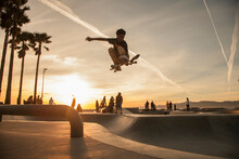 Teenage Boy Skating At Skatepark During Sunset