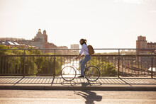 Man Riding Bicycle On Bridge