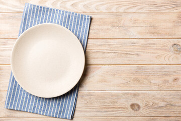 Sticker - Top view on colored background empty round white plate on tablecloth for food. Empty dish on napkin with space for your design