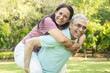 © GAJENDRRA BHATI  - Happy indian senior couple enjoying life having fun at summer park, man giving piggyback ride to woman. vitality, Old people fitness.