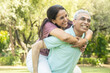 © GAJENDRRA BHATI  - Happy indian senior couple enjoying life having fun at summer park, Aging people, MATURE Husband giving piggyback ride to  wife.  Fitness healthcare, Relationship bonding.