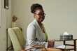 © AnnaStills - Portrait of African American professional psychologist looking at camera while sitting on armchair at office