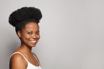 Portrait of joyful black woman sincerely laughing over gray background