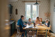 © pikselstock - Happy young family at dining table at home together