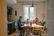 © pikselstock - Happy young family at dining table at home together