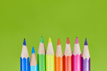 Wall Mural - rainbow colored pencils on a green background