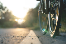 Road Bike Parked On A Beautiful Road Sunset, Warm Light With Copy Space.