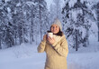 © kittyfly - happy mature woman 50 years old drink hot tea in winter forest, early evening in park among snow-covered trees, beautiful landscape, smiling happily, concept active lifestyle, enjoying winter nature