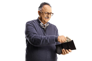 Wall Mural - Mature man smiling and putting money in a wallet