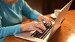 © Robert Peak - Extreme closeup of elderly womans hands while she types on laptop computer keyboard.