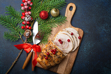 Wall Mural - Christmas baked ham sliced with red berries and festive decorations on wooden cutting board, dark rustic background from above. Christmas and New Year holiday dinner with baked pork 