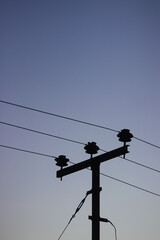 Electric pole silhouette with morning sky background.