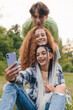 © Strelciuc - Group of diverse millennials people recording a video or taking a photo for social media. Young people having fun with new technology. Content creator concept