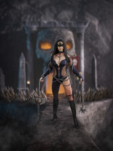 Beautiful Fantasy Warrior Woman Standing On A Stone Bridge Holding Deadly Weapons With A Skull Carved From Rock At A Cave Entrance Behind Her.  3D Illustration.