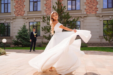 Wall Mural - beautiful blonde bride dancing and whirling in front of the groom.