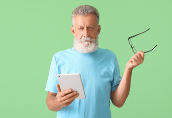 Sticker - Senior man with eyeglasses and tablet computer on green background