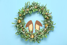 Paper Bunny Ears With Christmas Mistletoe Wreath On Blue Background