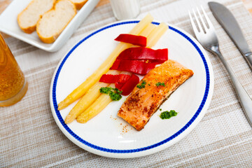 Wall Mural - Deliciously steak of fried salmon with asparagus, pepper and herbs on a ceramic plate