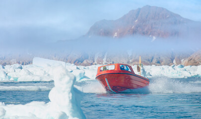 Wall Mural - fast moving motorboat trying to get out of the ice - stranded icebergs in the fog at the mouth of th