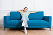 © Q88 - image of young Asian girl sitting on sofa at home