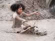 © chachamp - Funny African American kids girl playing in mud puddle