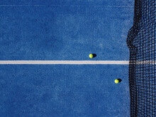 Overhead Aerial View Of Two Balls Near The Net Of A Blue Paddle Tennis Court. Racket Sports