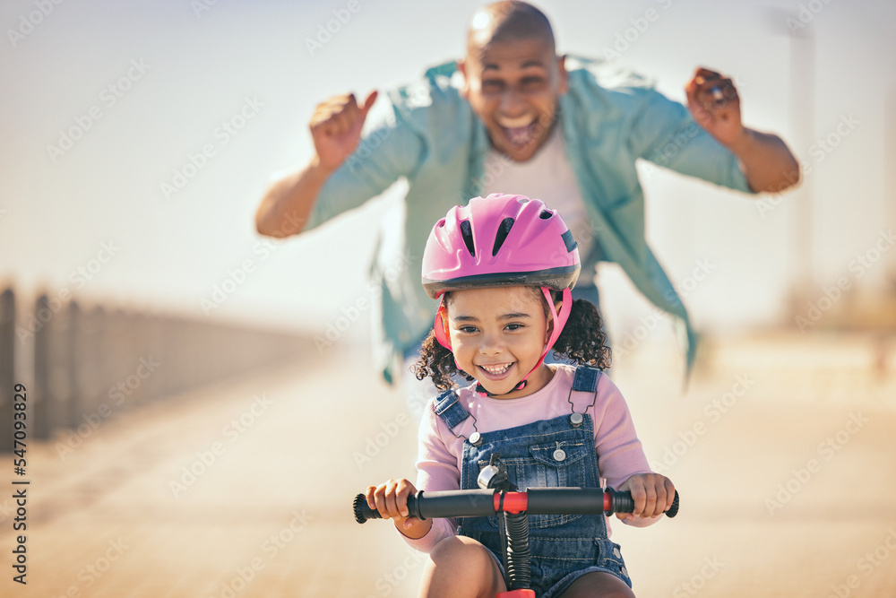 Excited father teaching girl to ride a bike in sunshine, summer fun and ...