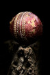 Cricket ball close-up used red leather on a wooden platform