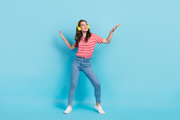 Full length photo of cheerful pretty lady look empty space enjoy cool event listen favorite playlist isolated on blue color background