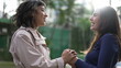 © Marco - Happy female friends laughing and smiling standing outside in sunlight holding hands for HELP and SUPPORT