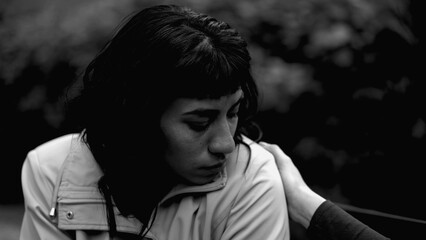 A depressed latin woman having the support of friend. Two women hugging each other in monochromatic. Sad person closeup face