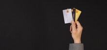 Hand Is Holding Three Credit Cards Isolated On Black Background. Hand Wear Suit..