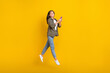 © deagreez - Full length photo of young influencer vietnamese jump air businesswoman hold phone remote work freelancer isolated on yellow color background