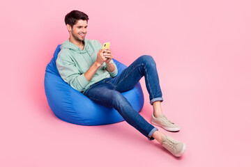 Aufkleber - Full length photo of positive man sit chair use modern device chatting followers write post empty space isolated on pink color background