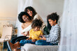 © NDABCREATIVITY - Family children gay parents concept. Happy multiethnic women couple having fun with kids at home