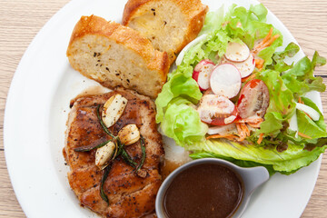 Wall Mural - Pork sirloin steak with gravy sauce, salad and garlic bread