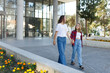© Алина Битта - Woman walking and chatting with daughter schoolgirl after school outdoors. Cheerful teen female speaking with mother in good mood. Talk concept