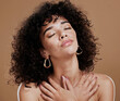 © J Maas/peopleimages.com - Woman, afro and relax in beauty for skincare, cosmetics or makeup against a brown studio background. Female holding body in satisfaction for healthy wellness, hygiene or self love and self care
