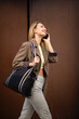 © mimagephotos - Profile of stylish young woman talking on mobile phone while walking in city