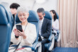 © maroke - 飛行機でスマホを使うシニア女性